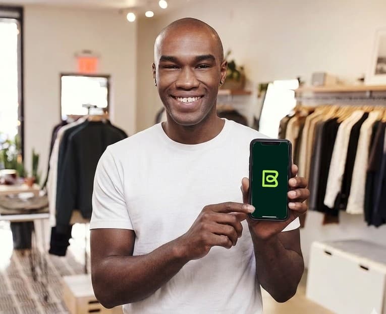 A business owner holding a phone showing the Bizlo app